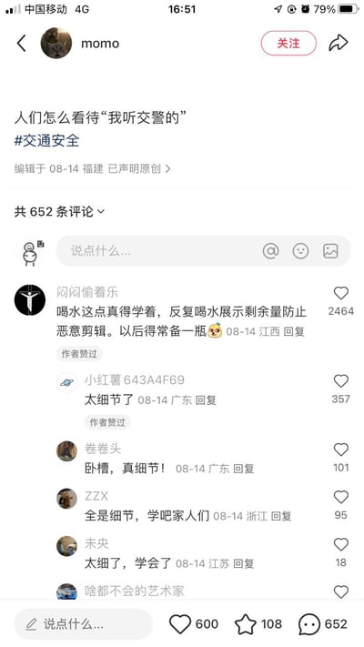 社交媒体用户'momo'发布的关于'人们怎么看待"我听交警的"'的讨论帖，带有#交通安全话题标签，编辑于08-14福建并声明原创。帖子下方有652条评论，热门评论提到'喝水展示剩余量防止恶意剪辑'等细节讨论，获2464点赞，其他评论多感叹'太细节了'。界面显示为典型的社交媒体评论区布局，包含用户头像、昵称、评论内容及互动数据。