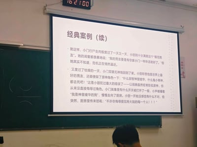 这是一张教室环境下拍摄的PPT投影截图，展示了一个充满反差感的搞笑原创故事：原本对女友言听计从、被称为“模范男友”的小门，在女友直接侮辱原神角色神里绫华、小草神后，触发了隐藏的“原神玩家”开关，从“听话男友”瞬间转变为维护提瓦特大陆的狂热粉丝，用怒吼表达对提瓦特角色的维护，故事结合了情侣日常与原神玩家的梗，制造出强烈的搞笑反差效果。