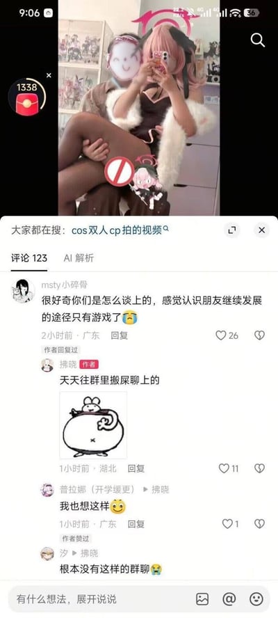 这是一张短视频平台评论区的手机截图。截图上半部分显示两位身着cosplay服装的人在室内自拍，其中一人戴着粉色假发、穿着黑色连衣裙和白色毛披肩，坐在另一人腿上，两人的脸部都被贴纸或手机遮挡，画面上还叠加了禁止符号和卡通人物等特效贴纸。截图下半部分是评论区，第一条评论由用户“msty小碎骨”发布，好奇作者是怎么脱单的，觉得只能通过游戏认识朋友。作者“拂晓”搞笑回复称“天天往群里搬屎聊上的”，并附带一个搞怪表情包。后续评论者纷纷表示羡慕，并调侃“根本没有这样的群聊”。顶部搜索栏显示“大家都在搜：cos双人cp拍的视频”。