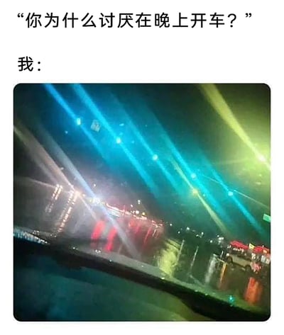这是一张吐槽夜间驾驶体验的梗图，上方以文字形式提出问题“你为什么讨厌在晚上开车？”，下方搭配一张从汽车内部视角拍摄的夜间道路实拍图：画面里道路上的各类灯光（包括对向车辆灯光）产生了严重的眩光效果，蓝、绿、白等各色光线杂乱刺眼，完全模糊了前方路况，直观且生动地展现出夜间开车时被强光晃眼、视线严重受阻的糟糕体验，精准回应了上方的问题，引发有相同驾驶经历人群的共鸣。