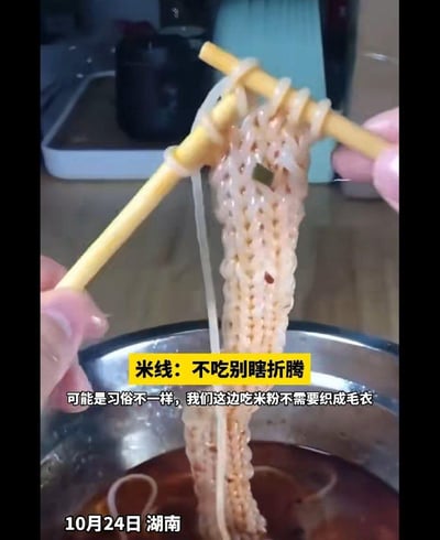 图片中展示了一双手用两根筷子将米线“编织”成类似毛衣的网状结构，米线被高高挑起，下方是盛有汤汁的金属碗。画面配有文字：“米线：不吃别瞎折腾”和“可能是习俗不一样，我们这边吃米粉不需要织成毛衣”，底部标注“10月24日 湖南”。整体通过将处理米线的动作夸张为“编织”，营造出幽默搞笑的效果，调侃了这种独特的食物处理方式。