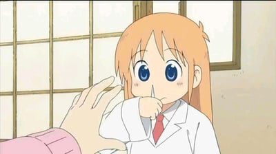 动漫《日常》中的场景截图，主角纳米· Shinonome（橙色长发、蓝色大眼睛）穿着白色实验服搭配红色领带，脸颊泛红，表情害羞，右手轻触嘴唇。画面左侧有一只手伸向她，背景是传统日式木质推拉窗。整体氛围可爱温馨，展现了角色的腼腆特质。