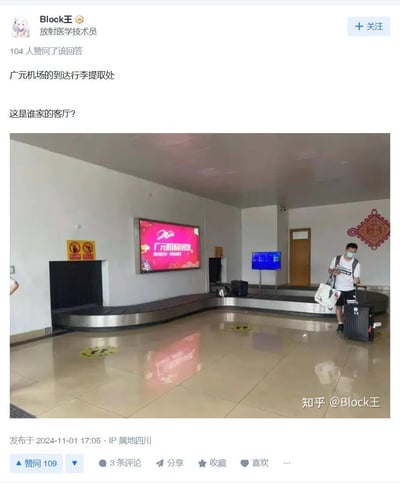 知乎用户“Block王”发布的帖子截图，内容为广元机场到达行李提取处的实拍照片。画面中行李提取区域空间较小，配备环形传送带、红色电子显示屏（显示“广元机场欢迎您”）、黄色警示标识及墙上的红色中国结装饰，一名戴口罩男子正拖着行李箱行走。配文“这是谁家的客厅？”以幽默口吻调侃该区域因面积小巧、装饰居家化而酷似普通客厅，引发网友共鸣。