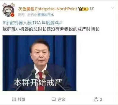 这是一张在中文社交媒体发布的搞笑梗图，博主带话题#宇宙机器人获TGA年度游戏# 发文调侃“我群玩小机器的总时长还没有尹锡悦的戒严时间长”，并配上一张经过文字修改的韩国总统尹锡悦的公开讲话图，将原本的发言内容替换为“本群开始戒严”，用玩游戏时长和“戒严”的梗结合，对TGA年度游戏进行搞笑吐槽，属于游戏玩家社群的趣味玩梗内容。
