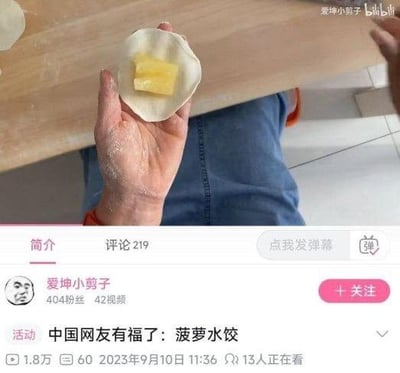 这是B站用户“爱坤小剪子”发布的视频截图，画面中一只沾着面粉的手拿着饺子皮，里面包的不是常规的肉馅，而是一块菠萝果肉，视频标题为“中国网友有福了：菠萝水饺”，是一种创意十足的黑暗料理式水饺制作，搭配新奇的食材组合，让人感到新奇又搞笑。