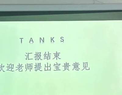 这是一张实拍的投影幕布上的PPT结尾页画面，页面底色为淡绿色，最上方原本应该用来表达感谢的英文单词THANKS出现拼写失误，被写为TANKS（意为坦克），下方搭配中文文案“汇报结束 欢迎老师提出宝贵意见”，明显是面向老师的课程汇报或者毕业答辩类演示文稿的收尾页，拼写错误形成了反差笑点，仿佛在“威胁”提意见的老师，颇具喜剧效果。
