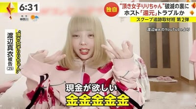 这是日本晨间新闻（画面左上角显示时间6:31，地区为神奈川）的视频截图，画面主体是25岁的渡边真衣，她的网络昵称是‘顶き女子りりちゃん’（中文意为‘被包养女子莉莉酱’）。她留着浅金色齐肩短发，身穿带有红色图案的粉色拉链上衣，双手做出夸张的手势，面部表情亢奋急切，正在大喊着想要现金。画面下方配有醒目的字幕‘想要现金 钱钱钱钱钱’，重复的‘钱’字强化了她对金钱的强烈渴望。画面右上角的新闻标题显示‘“被包养女子莉莉酱”的破灭背后 疑似与牛郎店的“返款”纠纷’，并标注这是‘独家追踪取材班第2弹’，右下角注明画面来源是‘被告渡边的YouTube’，说明该画面截取自渡边真衣自己发布的YouTube视频。整个场景呈现出该网络红人因金钱纠纷被新闻曝光的状态，她夸张的表现成为画面的核心看点。