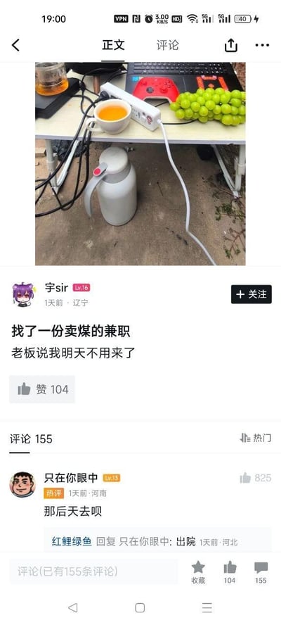 一张社交媒体截图，展示了一个凌乱的办公桌，桌上有茶壶、茶杯、插线板、葡萄、键盘和游戏手柄等物品。发帖人"宇sir"配文称自己找了一份卖煤的兼职，结果老板说明天不用来了。热门评论"那后天去呗"引发搞笑互动，回复"出院"更是增添了幽默效果。