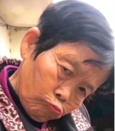这是一张通过视觉错位或者图像合成制作的趣味图片，画面中呈现出一个面部形态怪异的人物，五官严重扭曲错位，结合了人物真实的脸部和旁边的物体轮廓，形成了荒诞滑稽的视觉效果，容易让人产生人脸变形的错觉，这类图片常被用作搞笑表情包，在网络上传播以博人一笑。