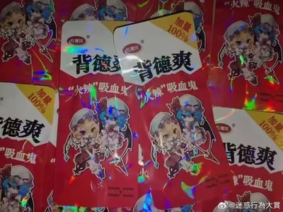 这是一组模仿国内辣条包装风格的二次元恶搞周边，包装主色调为鲜艳的红色，表面带有镭射反光效果，视觉上和常见辣条包装高度相似。包装顶部印有「红魔馆」标识，中间是醒目的大字「背德爽」，玩了谐音梗，既贴合辣条类零食的爽感描述，又结合东方Project红魔馆角色的「背德」二创设定；下方标注「“火辣”吸血鬼」，模仿辣条的「火辣」口味描述，对应红魔馆吸血鬼的身份，同时还有「加量100%」的字样，还原辣条包装的促销话术。包装上印有东方Project中红魔馆的蕾米莉亚·斯卡蕾特和芙兰朵露·斯卡蕾特的Q版形象，两个角色摆出活泼的姿势，底部还印有她们的英文名字「Remilia Scarlet & Flandre Scarlet」。整体将高冷的二次元吸血鬼角色与接地气的辣条包装结合，形成强烈的反差感，制造出搞笑、奇葩的恶搞效果。