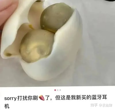 这张图展示了一个咸鸭蛋剥开后露出两个蛋黄，视觉上和蓝牙耳机的充电盒极为相似，搭配文字形成网络双关玩笑，是典型的视觉错觉趣图。

涉及网络谐音、暗示和幽默双关。