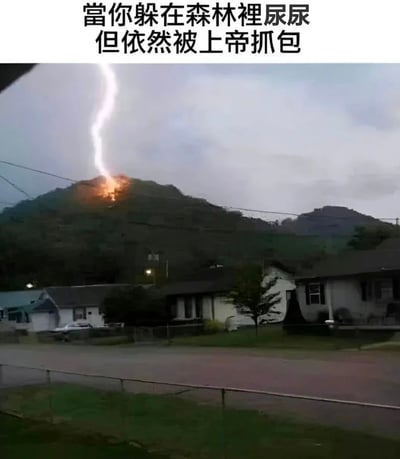 这是一张幽默梗图，上方配有文字“當你躲在森林裡尿尿 但依然被上帝抓包”，下方是一张真实照片，展示了一道闪电击中远处山顶并产生火光的场景，山脚下有几栋房屋。图片通过将闪电拟人化为“上帝抓包”的象征，用夸张的方式制造喜剧效果，暗示即使躲在隐蔽地方做不恰当的事也会被发现。