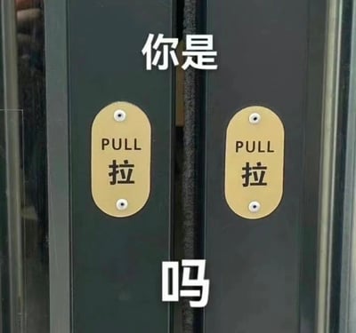 图片展示了两扇深色对开门，每扇门上各有一个金色的标识牌，上面分别用英文和中文写着'PULL'和'拉'。在两扇门的中间偏上位置有白色文字'你是'，中间偏下位置有白色文字'吗'，组合起来形成'你是拉吗'的问句。通过门上的'拉'字标识与上方文字结合，形成了一个语义上的趣味表达。