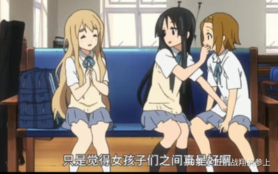 这是动画《轻音少女》的场景截图，画面呈现了社团教室内的温馨一幕：琴吹紬双手合十，一脸温柔感慨；秋山澪伸手捂住田井中律的嘴，律露出惊讶的神情。下方配文“只是觉得女孩子们之间真是好啊”，精准传递出对女生间亲昵温馨友谊的羡慕与感慨，没有双关、谐音梗或暗示内容。