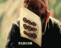 图中展示一个人用一块印有红色圆形图案的黄色警告牌布遮住了整个面部，背景模糊，主要焦点在遮脸的布上。布上的文字‘黄色警告牌’清晰可见，红色圆形图案排列在布的上方。