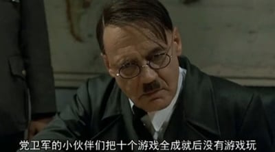电影《帝国的毁灭》中希特勒发怒片段的恶搞截图，画面中希特勒戴着眼镜，身着深色外套，表情愤怒地坐在桌前。下方配有恶搞字幕：'党卫军的小伙伴们把十个游戏成就全成就后没有游戏玩'，通过将严肃历史场景与游戏玩家常见的'成就全达成后无游戏可玩'的窘境相结合，形成幽默反差，属于'元首之怒'系列鬼畜作品。
