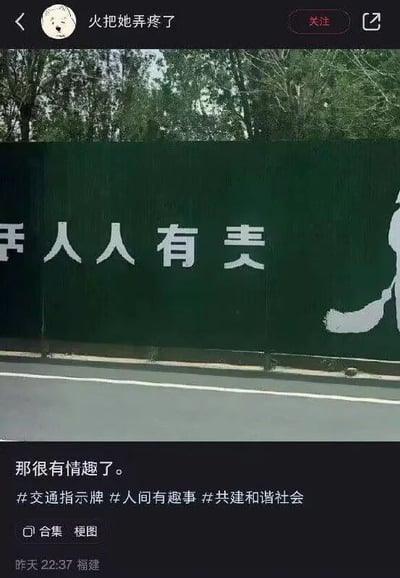 图片展示了一段绿色施工围挡，上面用白色涂料写着疑似错别字的标语“平人人人有妻”，背景可见树木和道路。围挡标语因文字排列或书写错误产生了歧义，原本可能想表达的积极宣传内容（如“平安人人有责”）变成了带有调侃意味的表述。下方是社交媒体用户“火把她弄疼了”的帖子，配文“那很有情趣了。”并带有#交通指示牌 #人间有趣事 #共建和谐社会 等话题标签，整体营造出一种因文字失误引发的幽默效果。