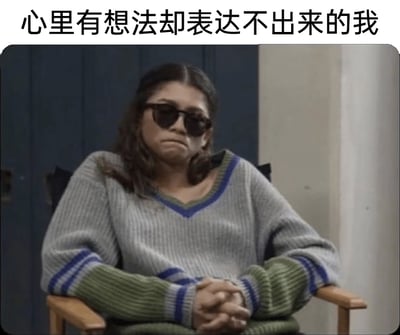 这是一张经过文字改编的影视截图表情包，图中人物是美剧《亢奋》里的鲁·贝内特，由赞达亚饰演。她戴着墨镜，嘴角下撇，神情低落又憋屈，双手交握放在身前，端坐在椅子上，姿态拘谨低落。图片顶部配上了文字“心里有想法却表达不出来的我”，将人物的憋屈神情与“词不达意、有口难言”的情绪精准结合，生动地表现出内心思绪万千却无法顺利表达，只能将情绪憋在心里的无奈与郁闷，很容易让有类似经历的人产生强烈共鸣。