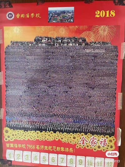 这是曾国藩学校2018年推出的新年主题海报，将7958名师生的照片拼接成超大型的“全家福”视觉效果，画面上方是学校名称、2018年份和学校俯瞰图，底部是新年祝福文字和2018年日历，整体以红色为底色，搭配烟花图案，营造出热闹的新年氛围，用密集的人像组合呈现出学校庞大的师生规模，视觉冲击力极强。