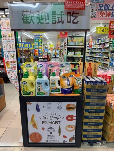 这是在中国台湾全联福利中心（PX MART）超市内拍摄的场景，一个标注着「歡迎試吃」的促销展示台，并未摆放常规的试吃食品，反而摆满了「天然油派水晶肥皂」、衣物清洁剂等家用清洁洗护产品，与试吃台的定位形成强烈反差，营造出荒诞搞笑的效果。
核心笑点在于场景错位：试吃台本是用于推广可食用商品的区域，却被用来陈列清洁用品，这种不符合常规的摆货方式显得格外离谱滑稽。