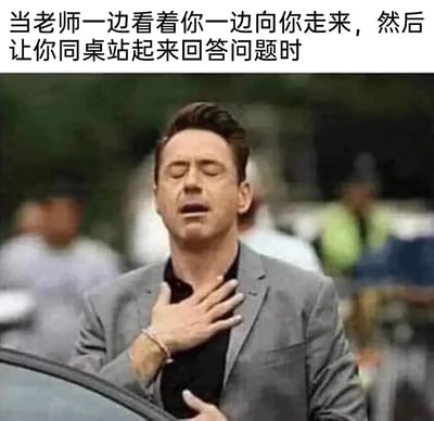 图片上方配有文字“当老师一边看着你一边向你走来，然后让你同桌站起来回答问题时”，下方是一张真人照片。照片中男子（罗伯特·唐尼·朱尼尔）闭眼、手抚胸口，表情放松地呼气，完美还原了学生以为老师要提问自己，最终却点到同桌时的释然心情。这一场景精准戳中校园生活中“虚惊一场”的共同记忆点，充满搞笑与共鸣感。