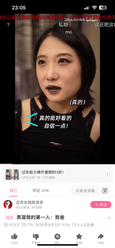 这是B站UP主「丑穷女孩陈浪浪」的视频《男凝我的第一人：我爸》的播放界面截图。画面中的女孩画着哥特风格妆容，包括深色哑光唇妆、眼下闪片装饰、鼻钉，眼神流露低落情绪；画面配有暖心鼓励文字「(真的) 真的挺好看的 自信一点！」，但上方弹幕出现「这丑吧这」「哥特风心都凉透了」等负面评价。下方显示B站视频界面信息：视频发布于2024年8月2日，播放量37.3万，UP主拥有6.6万粉丝，还有广告栏、评论区入口等元素，整体呈现出容貌评价的争议与鼓励自信的反差。