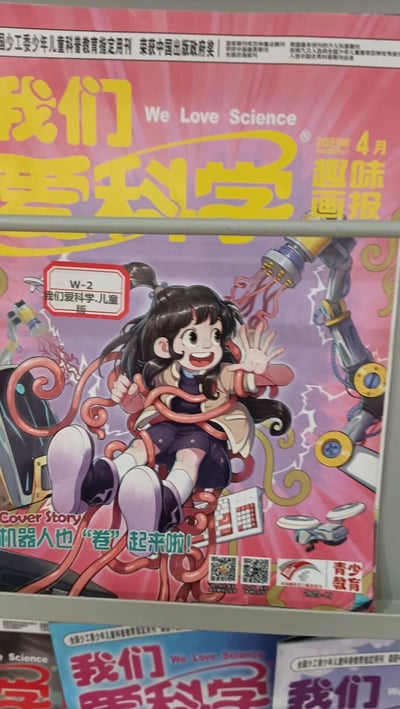 《我们爱科学 趣味画报》2025年4月号封面实拍图，以粉紫色渐变为主色调，中央是一位扎双马尾的卡通女孩，面带灿烂笑容，左手向前挥手互动，右手握着红色螺旋状机械臂。女孩周围环绕着银色机器人手臂、齿轮和闪电状线条等科幻元素，背景中还有显微镜等科学仪器图案。顶部有黄色大字标题“我们爱科学”及英文“We Love Science”，右上角标注“2025年4月 趣味画报”，左上角有“团中央少工委儿童科普教育指定用刊 荣获中国出版政府奖”字样，底部“Cover Story: 机器人也‘卷’起来啦!”点明本期主题，整体风格活泼童趣，充满对科学的探索感。