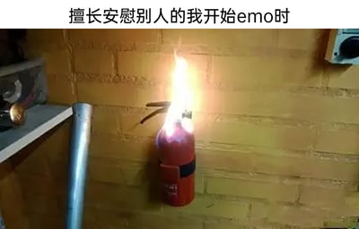图片展示了一个本应用于灭火的红色灭火器，此刻却自身燃起熊熊火焰，被固定在黄色砖墙背景上。上方配有文字“擅长安慰别人的我开始emo时”，通过灭火器（象征安慰者）自身着火（象征陷入emo情绪）的强烈反差，形成生动隐喻：平时像灭火器一样帮助他人扑灭负面情绪的人，当自己陷入emo时却无力自救，展现出一种无奈又带点自嘲的情绪状态。