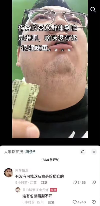 图片为社交媒体竖屏截图，内容是一名戴眼镜的男子手持一包猫条，仰头露出困惑表情。画面上方配有文字：“猫条的受众群体到底是谁啊，啥味没有还很腥味重。。。。”，表达了对猫条味道和受众的疑惑。截图下方显示评论区，其中高赞评论“有没有可能这玩意是给猫吃的”（用户“同命相连”）和“这有包装猫撕不开”（作者“官口鲜潜江小龙虾”）形成搞笑互动，揭示了人类误食宠物食品的乌龙场景。整体风格轻松幽默，充满生活气息的误会笑点。