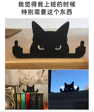 图片上方配有文字“我觉得我上班的时候特别需要这个东西”，下方由三张图片组成。主图展示一个黑色猫咪造型的摆件，猫咪双眼圆睁，表情凶狠，双手做出竖中指的动作，放置在木质桌面上。左下角图片中，该摆件被放在书架上，周围是不同颜色的书籍；右下角图片中，摆件置于窗边，背景是蓝天。整体通过幽默叛逆的猫咪形象，表达了打工人在工作中的无奈情绪，用可爱又带点“暴躁”的设计戳中职场人的共鸣点。