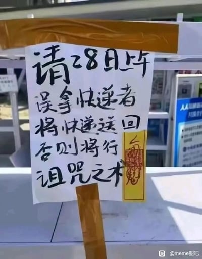 这是一张拍摄于快递存放点的实景照片，画面核心是一张用胶带固定的手写告示。告示以黑色毛笔字体书写，内容为“请28日上午误拿快递者将快递送回，否则将行诅咒之术”，在告示右侧还搭配了一张模仿道教符咒样式的黄色贴纸，贴纸带有红色印画与符文。整体风格诙谐搞笑，失主用带有迷信色彩的“诅咒之术”作为另类的催还手段，既传递出快递被误拿后的无奈情绪，又以幽默夸张的方式试图让误拿快递的人重视并归还包裹，是生活中趣味十足的小场景。