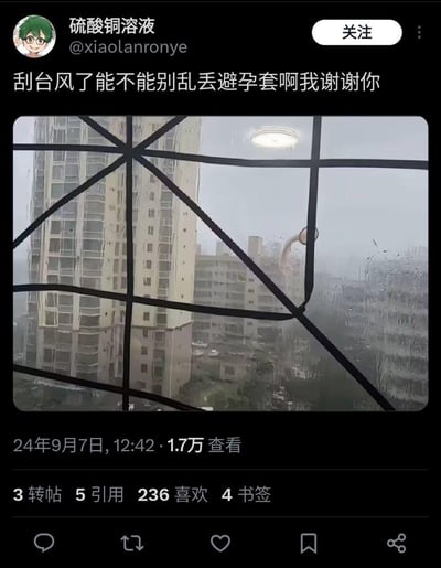 这是一条社交媒体上的吐槽帖子，发布者在台风天气中，透过自家窗户看到窗外飘着一个避孕套，于是发文吐槽“刮台风了能不能别乱丢避孕套啊我谢谢你”。画面里是台风天灰蒙蒙的城市楼宇，雨水打在玻璃上，避孕套挂在窗边的防护栏附近，场景尴尬又好笑，充满了对这种不文明乱丢行为的无奈吐槽。