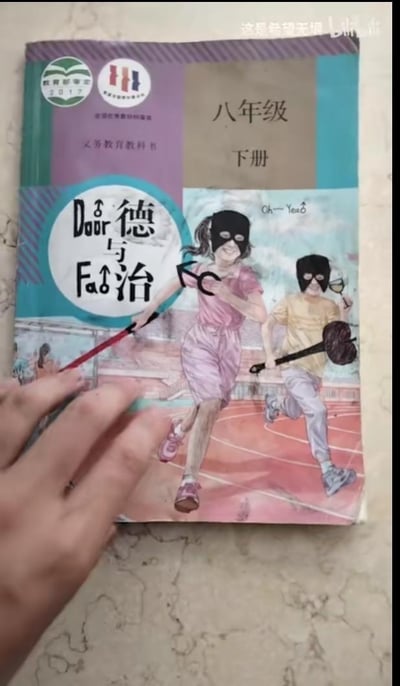 这是一张经过P图改编的人教版八年级下册《道德与法治》课本封面：原本的书名“道德与法治”被改成了谐音的“Door与Fao”，玩了“道（Dao）”与“Door”、“法（Fa）”与“Fao”的谐音梗；封面原本的两名学生被P上了黑色头套，手持类似撬棍、球棒的物品，做出奔跑欢呼的动作，还添加了“Oh~Yeah”的欢呼文字，将原本积极向上的课本封面恶搞成了类似“小偷作案得逞”的滑稽场景，通过强烈的反差感制造搞笑效果。画面左下角还有一只手正在触碰这本被修改的课本。