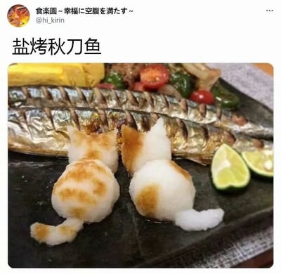 这是一份充满巧思的创意日式盐烤秋刀鱼料理，餐盘里的秋刀鱼表皮被烤得油光亮泽，带有清晰的烤炙纹路，看起来外酥里嫩。秋刀鱼前方摆放着两只由淀粉类食材制作而成的猫咪造型食物，猫咪的身体部分带有烤过的焦黄色斑纹，形态逼真可爱，为普通的料理增添了十足的趣味性与观赏性。餐盘内还搭配了切半的青柠、小番茄、青椒以及一块类似玉子烧的黄色食物，整体摆盘精致，色彩搭配和谐，既保留了日式料理的清爽质感，又通过可爱的造型打破了常规料理的呈现方式，没有双关、谐音梗或暗示类内容。