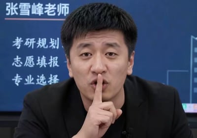 这是一张真人静态图片，主体是知名教育领域博主张雪峰，他身着黑色上衣，将右手食指放在嘴边做出噤声的嘘声手势，神态略带严肃，意在示意他人保持安静；他身后的蓝色背景板上标注有“张雪峰老师”的字样，还列出了他相关的服务领域：考研规划、志愿填报、专业选择，结合“为高考静音”的主题，该图用于呼吁社会公众在高考期间减少噪音，为考生营造安静的备考、考试环境。