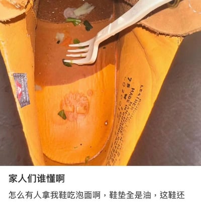 一张令人震惊的照片，展示了一只黄色的鞋子被用作容器来吃泡面。鞋内可以看到面条、蔬菜和汤汁，还有一把塑料叉子插在食物中。鞋垫上沾满了油渍，显然有人真的用这只鞋作为餐具。图片下方配有文字："家人们谁懂啊 怎么有人拿我鞋吃泡面啊，鞋垫全是油，这鞋还"，表达了原主人的震惊和无奈。这种非常规的用餐方式制造了强烈的视觉冲击和荒诞感，让人哭笑不得。