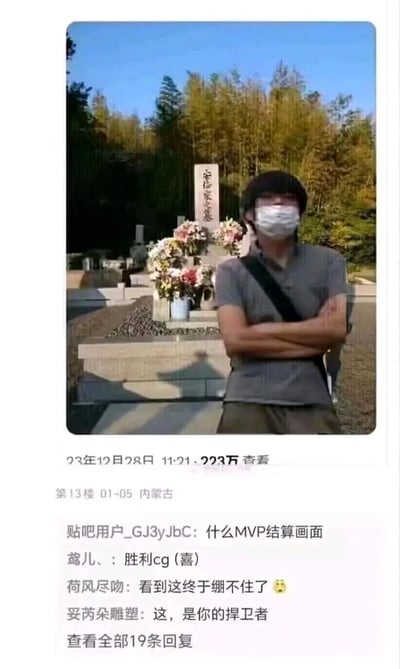 这是一张来自百度贴吧的社交媒体截图，上方是2023年12月28日发布的实拍照片，照片中一名佩戴口罩的男子双臂交叉站在刻有“安倍家之墓”的墓碑前，该内容累计获得223万查看量；下方是贴吧第13楼的评论区内容，网友们将原本肃穆的墓前场景与游戏内容结合玩梗，把这个画面调侃为游戏的MVP结算画面、胜利CG，还模仿游戏台词进行调侃，凭借场景与玩梗的强烈反差，让原本严肃的画面充满搞笑的网络氛围，引发其他网友的共鸣。
