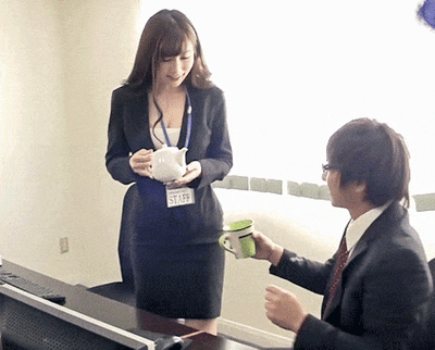 这是一个发生在办公室的动态GIF，画面中一位身着职业装、佩戴STAFF工牌的女职员手持茶壶，准备给坐着的男同事倒水，由于视觉错位的角度，看起来像是女职员直接从自己身体部位倒水，制造出荒诞滑稽的搞笑效果，通过巧合的视觉误差带来趣味笑点。
