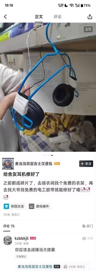 社交媒体截图，展示用户“麦当劳双层吉士汉堡包”分享的宿舍DIY修复耳机经历。图中一只手拿着用蓝色衣架和白色电工胶带修复好的黑色头戴式耳机，耳机原已碎成碎片，用户通过在洗衣间找免费衣架、向大爷要免费电工胶带完成修复。配文幽默带“喵”字语气词，体现大学生活的 resourcefulness 和动手能力。评论区热门评论“你应该去战锤当大技霸”调侃其修理技能。