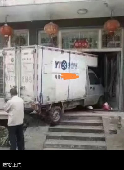这张图展示了一辆圆通速递的厢式货车，直接开进了居民住宅的大门内，停放在房屋的入口区域，完全字面意义上实现了“送货上门”。图片下方配文“送货上门”，用夸张的真实场景玩梗，以极端的方式呈现出“上门”的极致状态，充满荒诞搞笑的效果，调侃了快递行业的“送货上门”服务承诺。