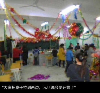 教室里挂满了五颜六色的彩带和气球，天花板上还悬挂着彩色的装饰球，营造出浓厚的节日氛围。学生们正在忙碌地布置场地，有的在调整桌椅，有的在准备物品，黑板前也有人在做最后的准备工作。地面上散落着一些紫色的装饰物，整个场景充满了热闹欢快的气息，大家都在为即将开始的元旦晚会做准备。