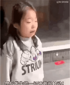 一个穿着灰色STRIUM卫衣的小女孩在室内环境中发表言论的表情包。她表情严肃，似乎在进行某种政治或社会评论。图片包含四句中文文字："是革命前辈换来的吗"、"没有亲人"、"我们并不欢迎你"和"如果你再进一遍你喜欢口水"，表达了强烈的排斥态度和政治意味。