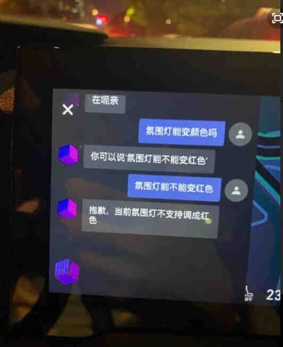 这是一张车载中控屏幕的界面截图，呈现了用户与车载智能语音助手的完整对话流程。界面背景为深色，对话内容以气泡形式区分：助手消息带有紫色立体图标，先回复“在呢亲”响应唤醒；用户询问“氛围灯能变颜色吗”后，助手引导用户使用指定话术“氛围灯能不能变红色”进行提问；用户按照引导发送问题，最终助手告知用户当前车辆的氛围灯不支持调成红色。整个对话清晰展示了车载语音助手的交互逻辑和对氛围灯功能的说明。