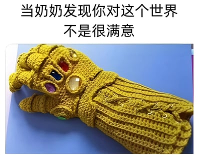 图片上方配有文字'当奶奶发现你对这个世界不是很满意'，下方是一只手工编织的金色手套，手套上镶嵌着红、蓝、紫、黄等彩色宝石，造型酷似漫威电影中的无限手套。通过奶奶手工制作的温暖意象与无限手套的强大毁灭力形成反差萌，幽默地表达了当奶奶察觉晚辈对世界不满时，可能会用自己的方式'解决'问题的搞笑场景。