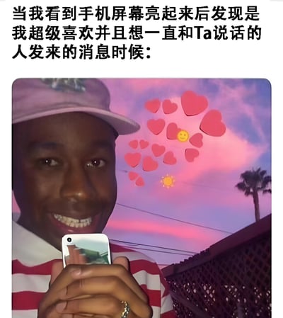 图片上方有一段文字：'当我看到手机屏幕亮起来后发现是我超级喜欢并且想一直和Ta说活的人发来的消息时候：'。下方是一张照片，照片中一个戴着粉色帽子、穿着红白条纹上衣的人正开心地拿着手机，背景是粉色和紫色渐变的天空，天空上有许多红色爱心图案和一个黄色笑脸图案，右侧还有一棵棕榈树。