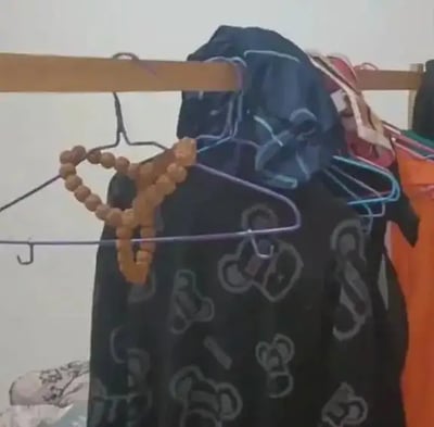 整张图片看似是一堆普通晾衣服的衣架，但最左侧的一个衣架上挂着佛珠项链，并被巧妙地摆成了类似情趣内裤（俗称easy裤）的形状。视觉上形成强烈的误导感，让人第一眼可能会误以为上面悬挂的是一条内裤，实际上却只是佛珠加衣架组合而成。这种“错位梗”“意外联想”带来幽默效果，非常适合用来调侃、玩梗。

图片中没有明显的谐音梗，但具有明显的错位双关意味。