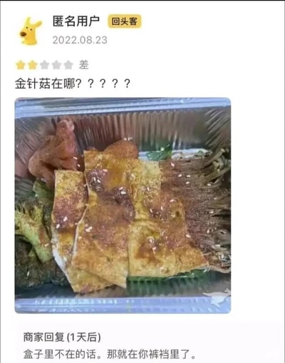 这是一张来自外卖平台的用户评价截图，2022年8月23日，一位标注为“回头客”的匿名用户给出两星差评，配文质问“金针菇在哪？？？？？”，并附上餐品实拍图，图中铝箔餐盒内的金针菇被其他食材部分遮挡，位于餐品右侧；商家在1天后给出态度恶劣的回复：“盒子里不在的话。那就在你裤裆里了。”，该回复用语粗俗，违背服务行业基本礼仪，在网络传播中引发对商家服务态度的争议，同时用户未发现被遮挡的金针菇也成为截图里的一个小乌龙点。