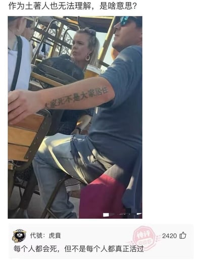 整张图为社交媒体内容截图，顶部配有提问文字“作为土著人也无法理解，是啥意思？”；主体实拍部分展示了一名戴墨镜的外国男性坐在户外休闲场所的座椅上，他的小臂上纹有一行语义不通顺的中文“大家死不是大家居住”；图片下方是皮皮虾平台的热门评论，用户“代號：虎賁”给出的神评内容为“每个人都会死，但不是每个人都真正活过”，该评论获赞2420，解释了该纹身原本想要表达的含义，推测是外国人在做中文纹身时因翻译错误、文字拆分排版失误，才导致最终纹出的文字语义完全不通，形成搞笑效果。