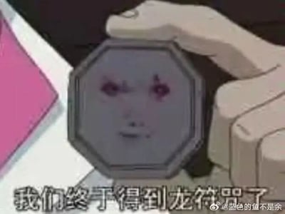 这是一张经过网友P图改编的动画截图，原始素材出自动画《成龙历险记》。画面中一只手握着原本是龙符咒的八边形物品，该物品被修改成带有呆滞人脸的图案，人脸双眼泛红，表情木讷，画面下方配有动画原台词“我们终于得到龙符咒了”，结合被篡改的符咒图案，形成强烈的反差搞笑效果，让原本充满魔力的符咒变得滑稽可笑，图片右下角带有微博用户“@蓝色的鱼不是余”的水印。
