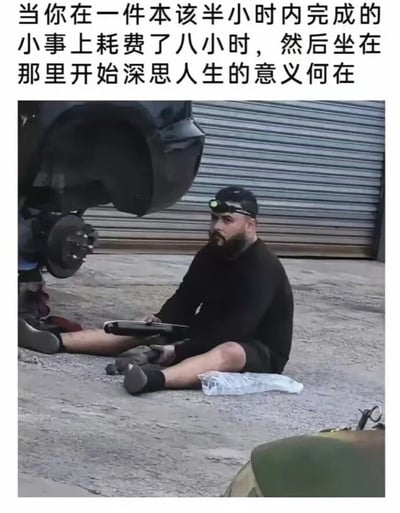 图片上方配有文字：'当你在一件本该半小时内完成的小事上耗费了八小时，然后坐在那里开始深思人生的意义何在'。下方是一张真人照片，一名男子坐在地面上，身旁停着一辆汽车，背景是灰色的卷帘门。男子戴着头灯，身穿黑色上衣和短裤，双腿伸直，手中拿着工具，神情显得有些疲惫和沉思，仿佛刚经历了长时间的劳作却效率低下，进而陷入对人生意义的哲学思考。